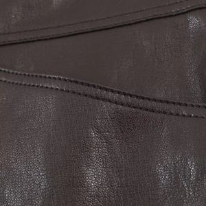 Vue macro du similicuir marron foncé avec texture détaillée et coutures de qualité