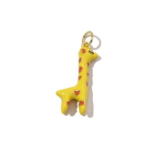 Close-up of yellow enamel giraffe pendant with red heart patterns for DIY jewelry