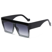 Close-up of retro oversized square sunglasses with black frame and grey gradient lenses