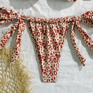 Detailed view of red leopard print bikini bottom with adjustable side tie bows