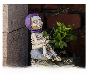 Detail of fishing skeleton figurine in purple hoodie for garden and aquarium decor
