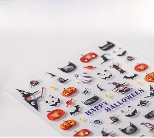 Macro view of Halloween nail stickers with pumpkins, witches, and ghosts on white base