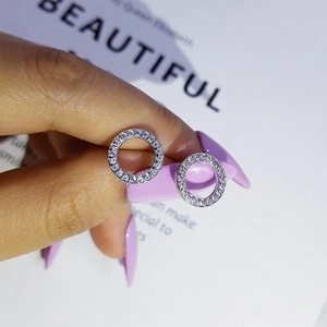 Macro shot of micro-paved silver stud earrings with sparkling round white crystals