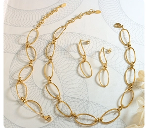 Detailed macro view of 18k gold geometric chain link necklace and bracelet jewelry set