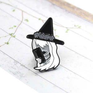 Detail of gothic enamel pin showing a girl in a witch hat taking a selfie with phone