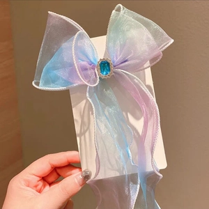 Detail of gradient tulle hair clip with blue gemstone and sparkling rhinestones