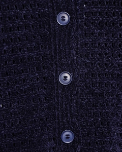 Macro di tessuto a maglia blu scuro che mostra la trama e i bottoni in resina verticali