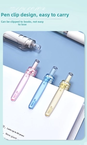 Close-up of jelly-colored retractable gel pens with pen clip on a white notebook