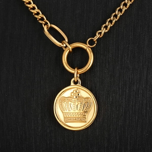 Close-up of 18k gold-plated crown pendant with large O-ring on textured background