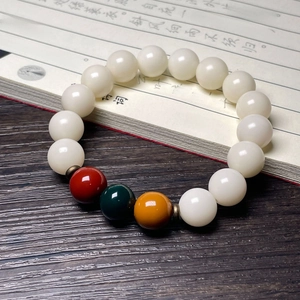 Detail of white Bodhi root beads with colorful accents on a vintage desk