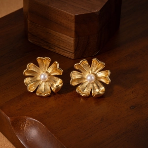 French vintage style gold flower earrings with central white pearl on dark wood