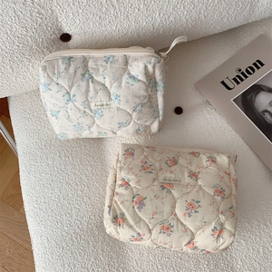 Close-up of quilted floral cosmetic bags showing cotton texture and zipper details