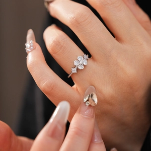 Close-up of elegant flower ring featuring four heart-shaped petals with sparkling zircons
