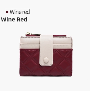 Detail of wine red quilted leather and cream white panel on a short bifold wallet