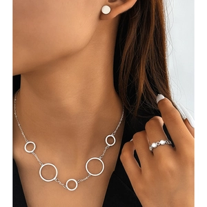 Minimalist silver geometric ring and necklace set worn by model in a modern style