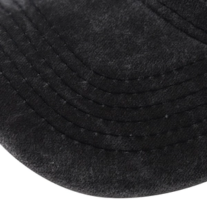 Detailed macro view of black baseball cap brim with parallel stitching and brushed cotton texture
