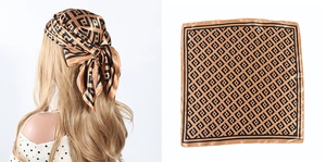 Detailed view of square satin scarf featuring black geometric patterns on a gold background