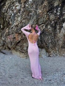Robe longue dos nu à manches longues rose en maille avec un arrière-plan côtier rocheux