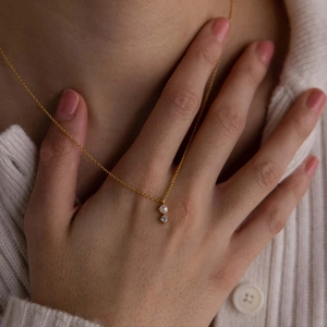 Minimalist gold titanium steel necklace with birthstone and small pearl pendant on model