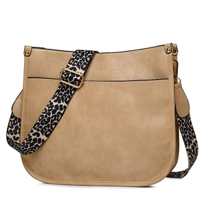 Detail view of khaki tote bag featuring a bold leopard print strap and golden hardware