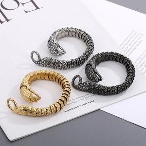 Close-up of snake skin texture bangles in gold, silver and black finish on lookbook