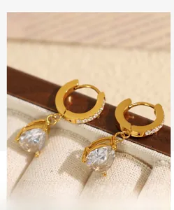 Détail de boucles d'oreilles goutte dorées avec zircon poire dans un coffret à bijoux
