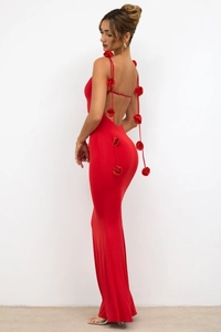 Détail d'une robe de soirée rouge dos nu avec des décorations de roses 3D sur les bretelles