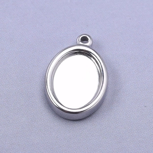 Macro shot of silver oval stainless steel pendant tray for DIY jewelry making with top ring