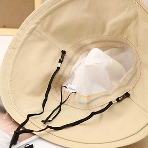 Detail view of beige kids wide-brim sun hat with adjustable strap and breathable lining