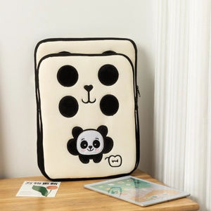 Dettaglio del ricamo panda su custodia beige per tablet appoggiata su un tavolo