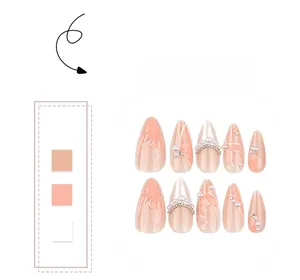 Détail de 10 faux ongles rose pêche avec perles 3D, billes dorées et chaînettes