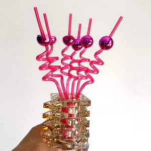 Close-up of pink disco ball decorative straws with spiral design for party decor