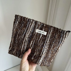 Close-up of brown and white tweed fabric texture with a simple wish brand label