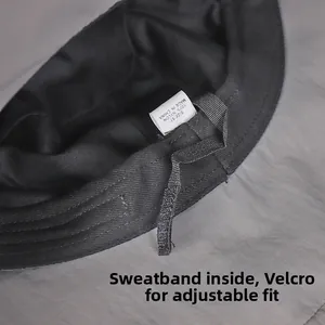 Detail eines grauen Nylon-Fischerhuts mit verstellbarem Klettverschluss und Schweißband