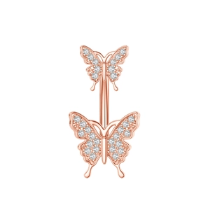 Macro view of a rose gold belly button ring with two crystal-studded butterfly charms