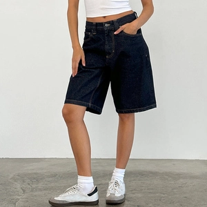 Detail of high-waist slim-fit dark blue denim shorts with sharp stitching craftsmanship