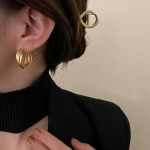 Minimalistische geometrische Gold-Creolen und Haarspange im Set an einem Modell