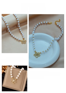 Detail of beaded pearl necklace with a vintage gold floral pendant and zircon accents