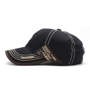 Detail of baseball cap featuring white contrast stitching and anchor metal badge