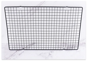 Close-up of a black non-stick rectangular cooling rack on a white marble background