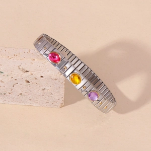 Elastic stainless steel bracelet with three oval gemstones and gold dot accents