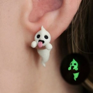Glow in the dark ghost earrings with pink tongue detail shown in daylight and night