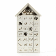 Detail view of the 24 small drawers on white wooden house advent calendar with snowflake icons