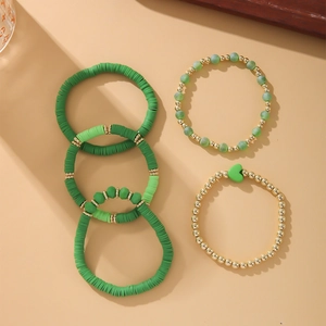 Detail view of Bohemian polymer clay bead bracelets set in shades of green and gold