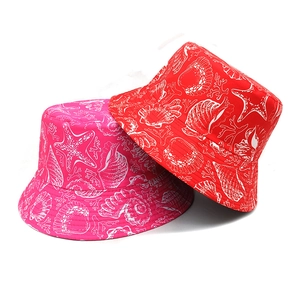 Pink and red bucket hats with ocean patterns including starfish and seashells on white background