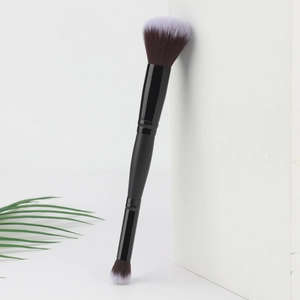 Gros plan d'un pinceau maquillage double embout avec poils poudre soyeux et embout ombre à paupières