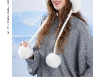 Dettaglio cappello invernale in pelliccia sintetica bianca con lacci e pompon