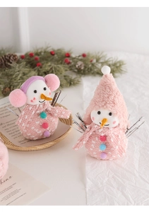 Detailed view of plush pink Christmas snowmen with knitted scarves and fuzzy hats