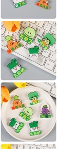 Macro detail of cartoon vegetable enamel pins with funny puns on a keyboard background