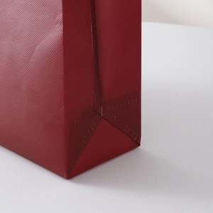 Deep red non-woven tote bag with vintage floral texture and heat-pressed bottom seal